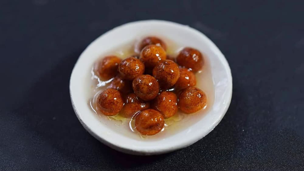 Glistening gulab jamuns in syrup Glistening gulab jamuns in syrup