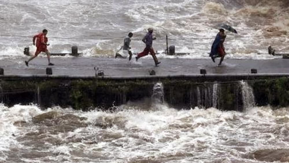 An NDRF worker runs across Cheruthoni bridge in Kerala with a child in his arms as it begins to flood An NDRF worker runs across Cheruthoni bridge in Kerala with a child in his arms as it begins to flood