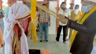 Social Distancing Wedding at Dhar: Bride And Groom Exchange Varmala Using Wooden Sticks During Lockdown (Watch Video)