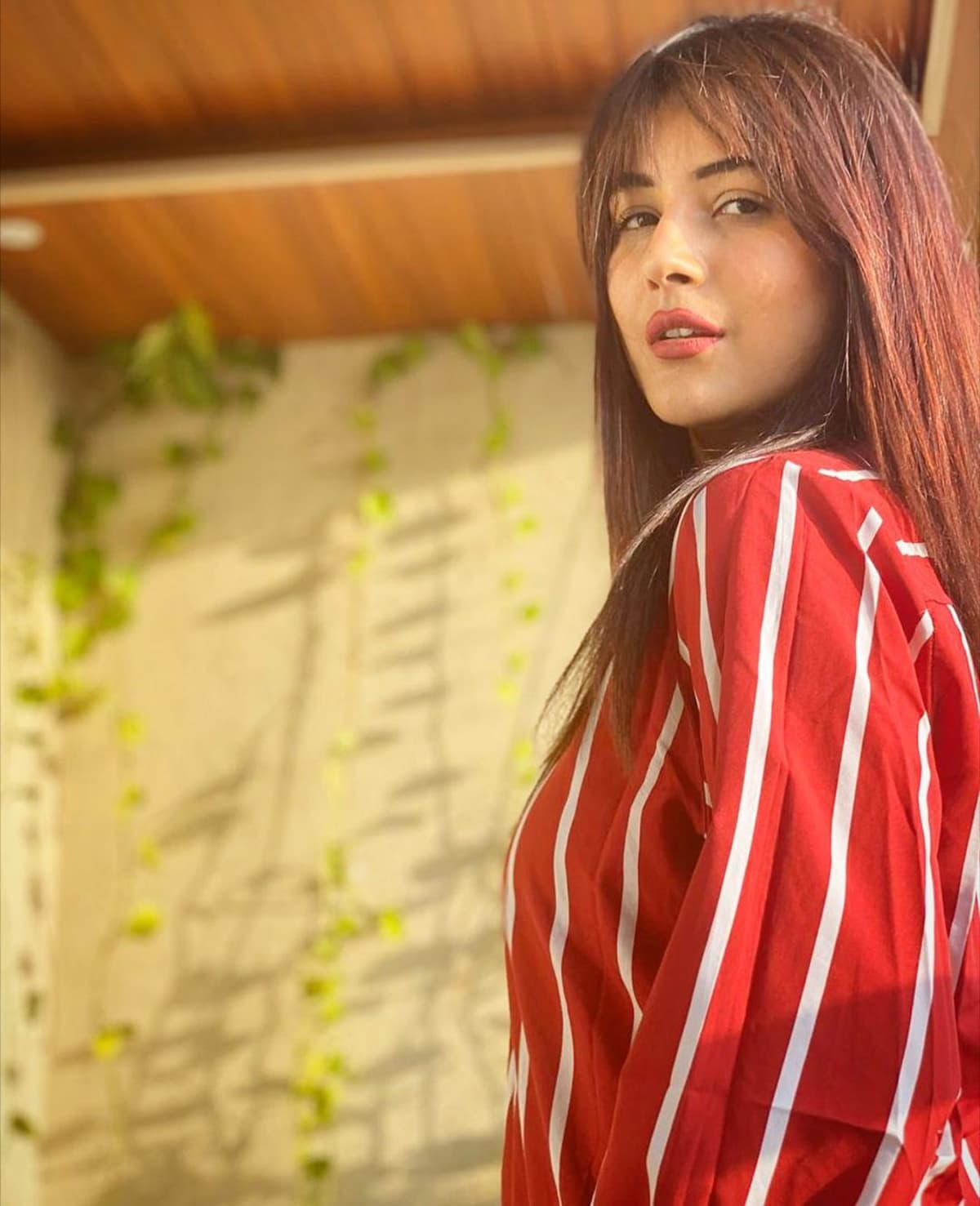 Shehnaaz looks both cute and hot in equal parts in this red and white pinstripe outfit. Shehnaaz looks both cute and hot in equal parts in this red and white pinstripe outfit.