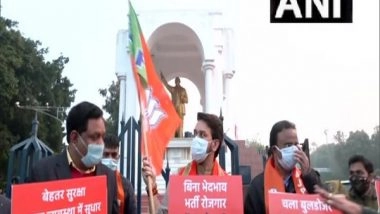 India News | UP Polls: Anurag Thakur Holds Placard, BJP Flag in Lucknow During Election Campaign