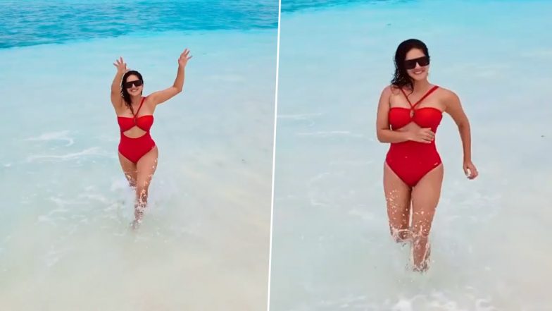 Hot! Sunny Leone Goes the Baywatch Way as She Waves On The Beach in a Red Bikini (Watch Video)