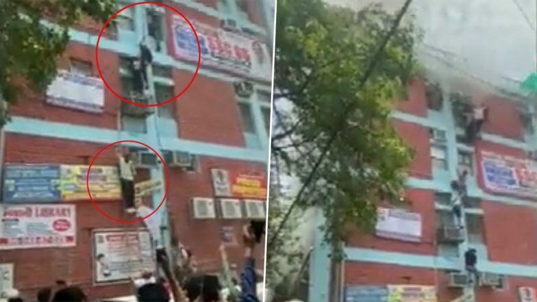 Delhi's Mukherjee Nagar Fire Video: People Use Wire Cables To Climb Down From Building After Blaze Erupts in Coaching Centre, Rescue Operation Underway (Watch)