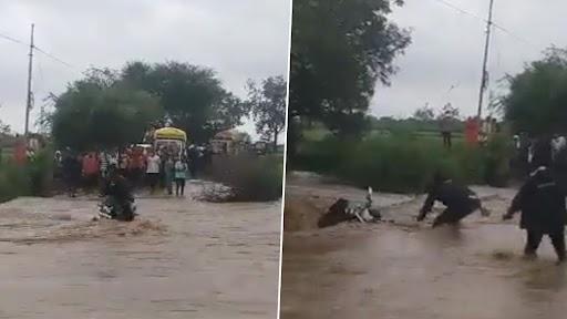 Maharashtra Rains: Biker Narrowly Escapes Being Washed Away in Flood Water in Hingoli, Motorcycle Swept Away (Watch Video)