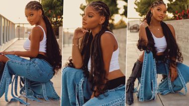 Halle Bailey Rocks Chic Street Style in White Tank Top, Blue Knee-High Slit Jeans, and Grey Boots (View Pics)