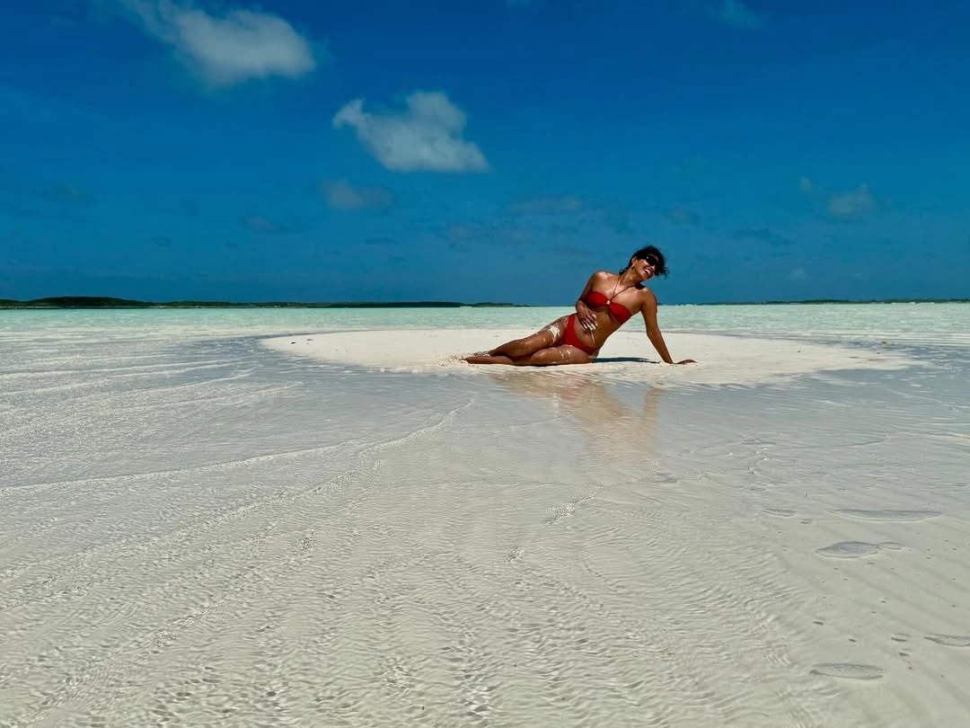 The global icon stuns in a vibrant red two-piece, exuding confidence and vintage charm.