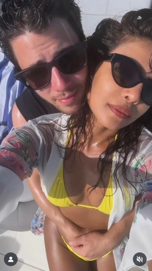 The couple shares a tender embrace, blending romance and relaxation in their tropical escape.