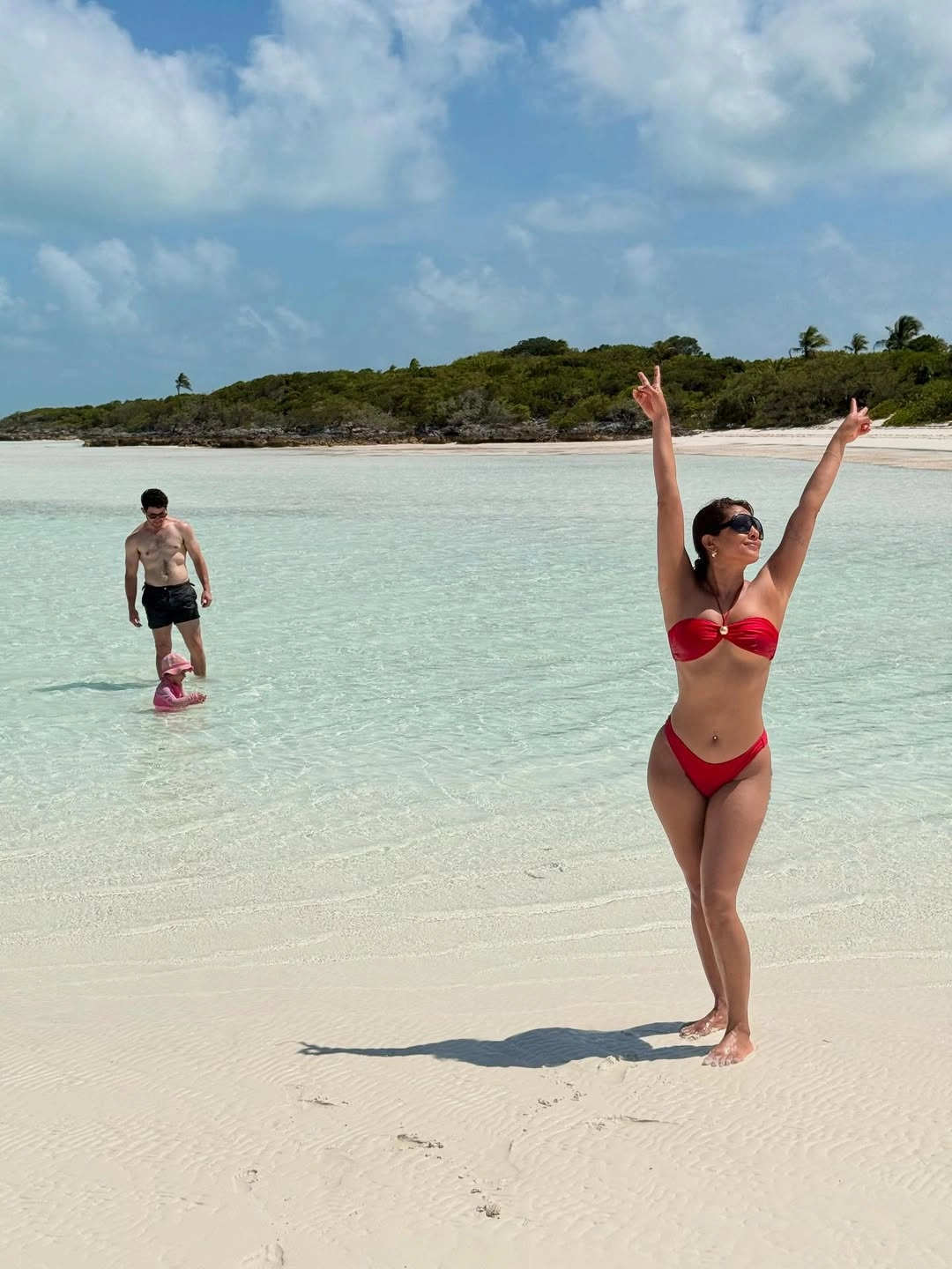 The fiery hue enhances her bronzed skin and brings an effortlessly glamorous edge to her beach look.