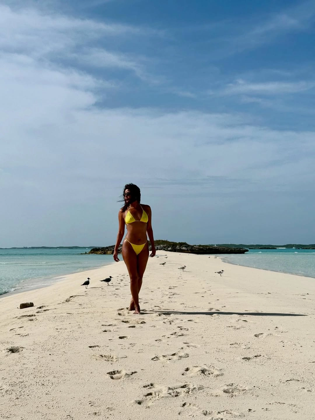 The striking yellow two-piece adds warmth and energy to her sun-soaked birthday moments.