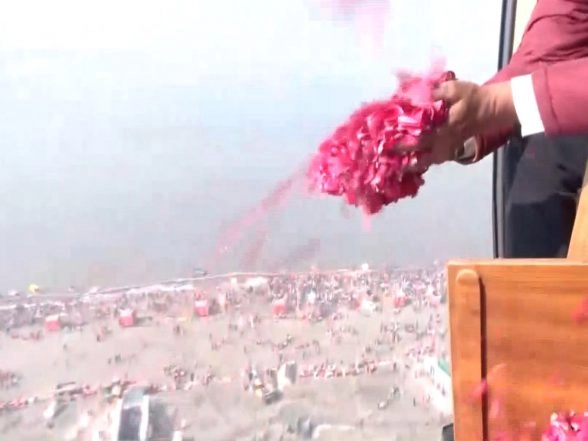 India News | UP: Flower Petals Showered on Devotees at Sangam on Mauni Amavasya