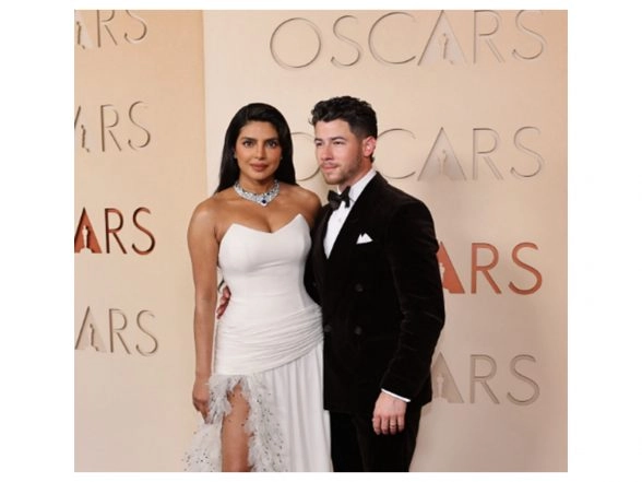 Entertainment News |  Oscars 2026: Priyanka Chopra Stuns in White Dior Gown, Walks Red Carpet Hand-in-hand with Husband Nick Jonas