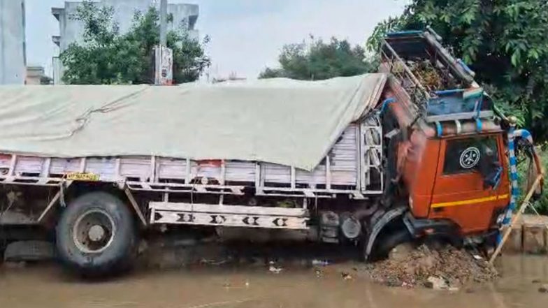 India News | Haryana: Cement-laden Truck Sinks into Road in Gurugram Sector 9 Amid Heavy Rain, Waterlogging