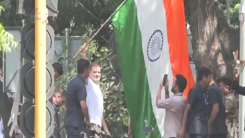 India News | Tricolour in Hand Rahul Gandhi Climbs Barricades, Sets Tone for INDIA Bloc Protest Against CEC